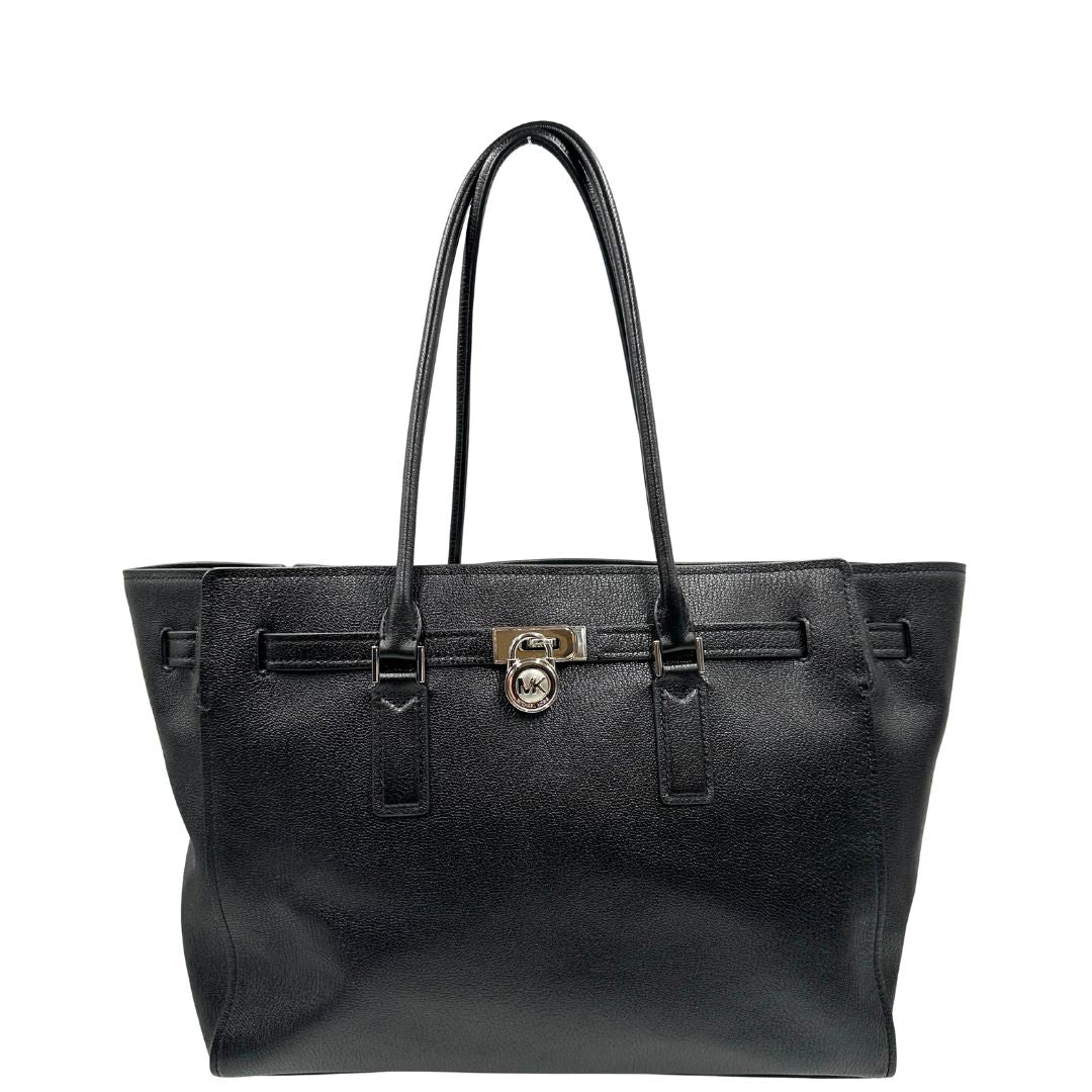 Front di una borsa Michael Kors in pelle nera con parti metalliche argentate; munita di doppi manici. Completa di dustbag. Indossabile a spalla.