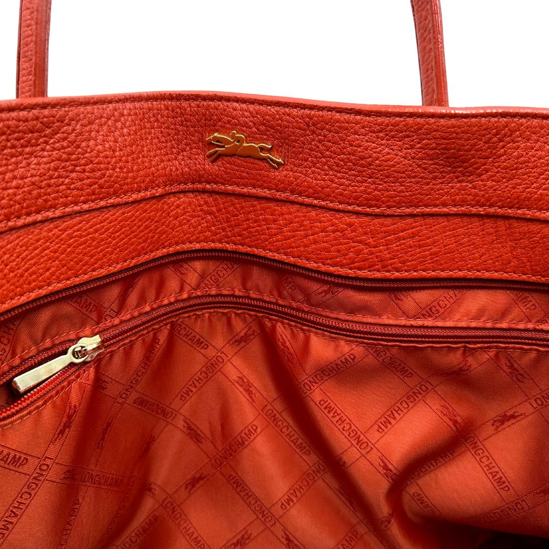 interno Borsa Longchamp in pelle martellata rosso corallo con parti metalliche dorate; munita di doppi manici, indossabile a spalla. Completa di dustbag, di lusso, originale, ottime condizioni. 