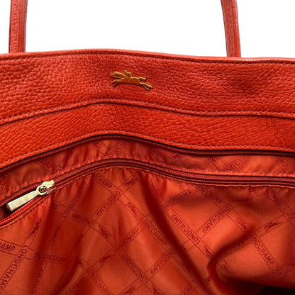 interno Borsa Longchamp in pelle martellata rosso corallo con parti metalliche dorate; munita di doppi manici, indossabile a spalla. Completa di dustbag, di lusso, originale, ottime condizioni. 