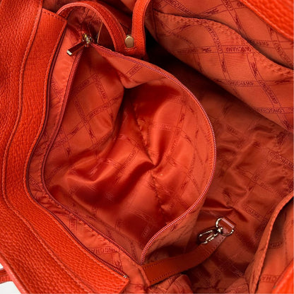interno Borsa Longchamp in pelle martellata rosso corallo con parti metalliche dorate; munita di doppi manici, indossabile a spalla. Completa di dustbag, di lusso, originale, ottime condizioni. 