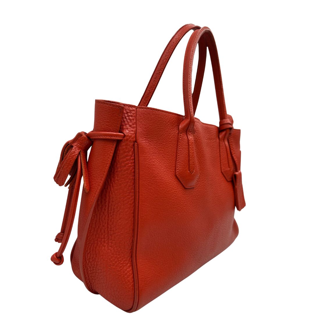 lato Borsa Longchamp in pelle martellata rosso corallo con parti metalliche dorate; munita di doppi manici, indossabile a spalla. Completa di dustbag, di lusso, originale, ottime condizioni. 