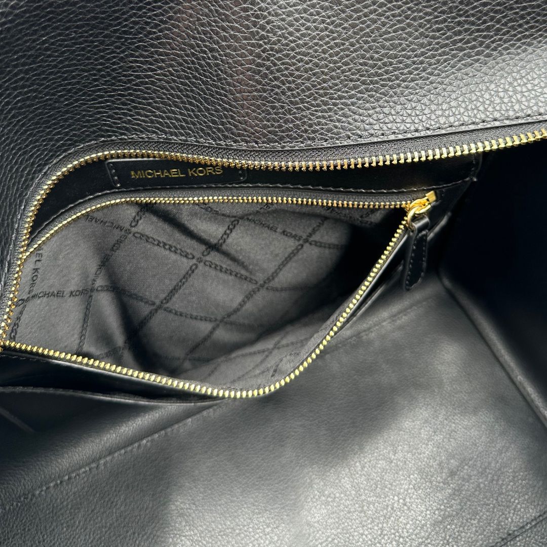 interno  Borsa MK in pelle martellata nera con parti metalliche dorate; munita di doppi manici, indossabile a spalla, di lusso, originale, ottime condizioni, usata. 