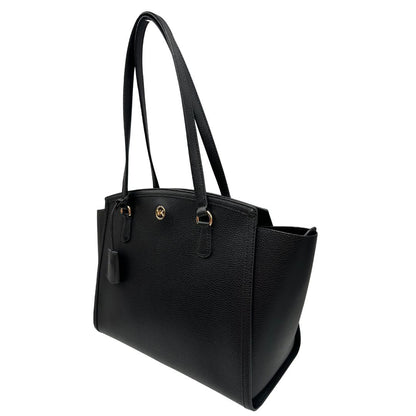 lato  Borsa MK in pelle martellata nera con parti metalliche dorate; munita di doppi manici, indossabile a spalla, di lusso, originale, ottime condizioni, usata. 