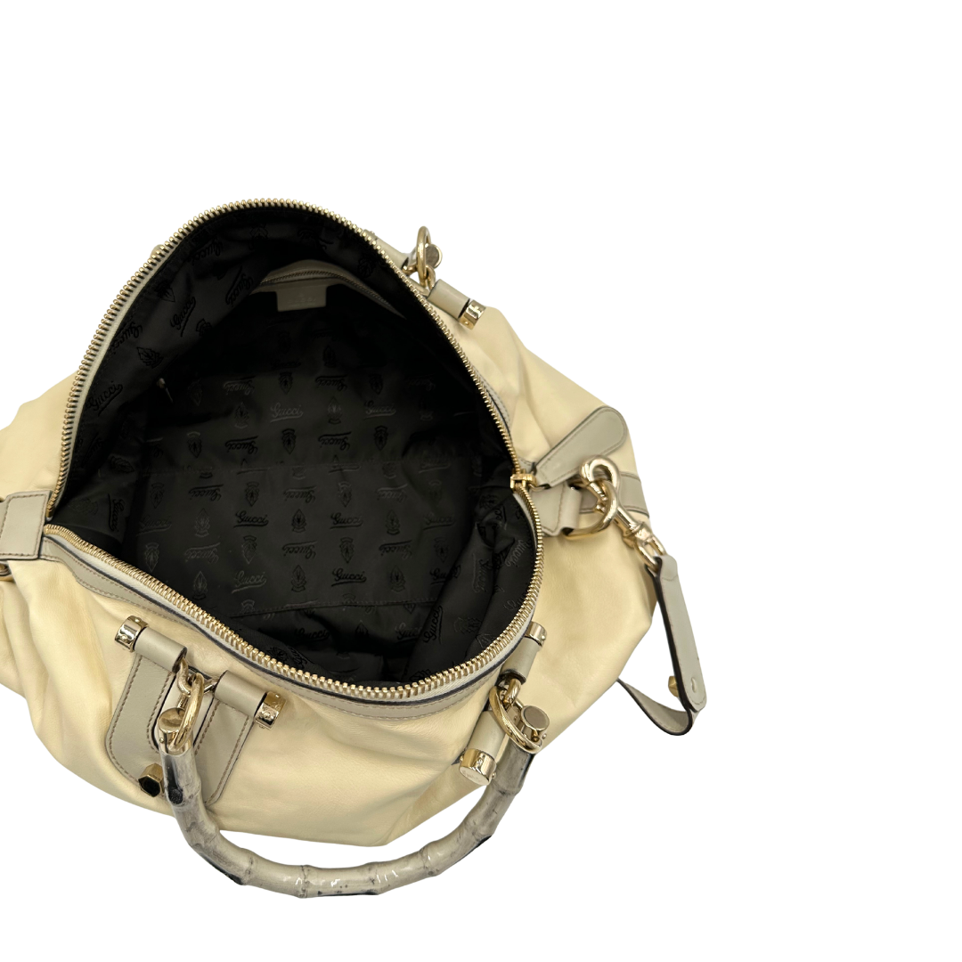 Interno di una Borsa Gucci in pelle bianco panna con metalleria in oro dorato e inserti in pelle avorio, munita di doppi manici in bamboo e tracolla amovibile. Completa di dutsbag. Originale, usata, di lusso, in ottime condizioni.
