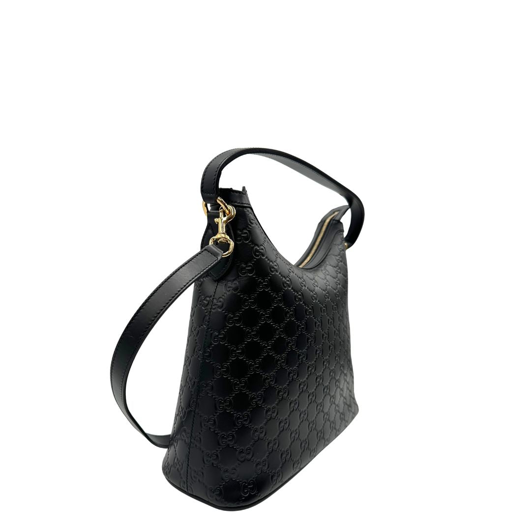 Lato destro, Borsa Gucci in pelle nera GG con hardware dorato. Originale, usata, di lusso, in condizioni eccellenti.