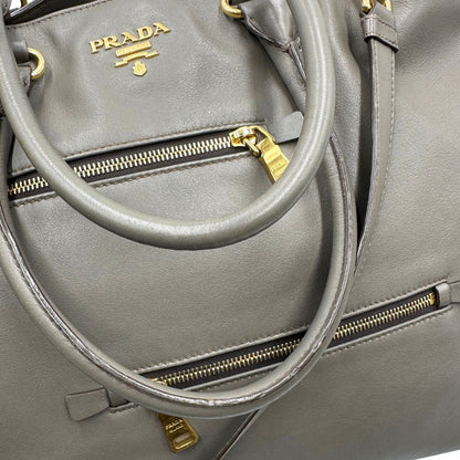 manici Borsa Prada in pelle color tortora con tracolla e parti metalliche dorate, di lusso, originale, ottime condizioni, usata. 