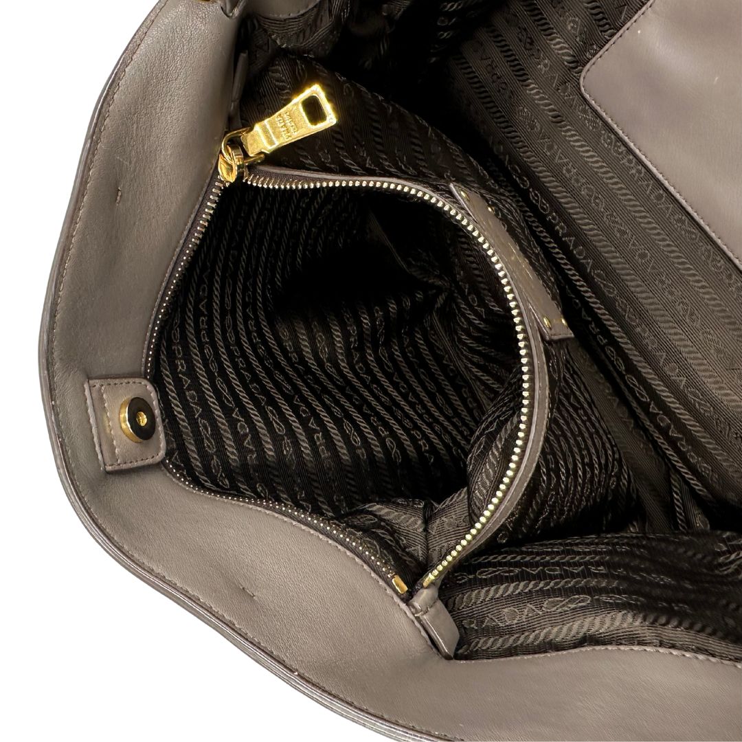 interno Borsa Prada in pelle color tortora con tracolla e parti metalliche dorate, di lusso, originale, ottime condizioni, usata. 