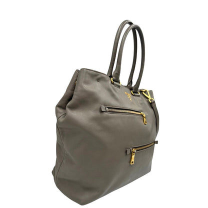 lato Borsa Prada in pelle color tortora con tracolla e parti metalliche dorate, di lusso, originale, ottime condizioni, usata. 