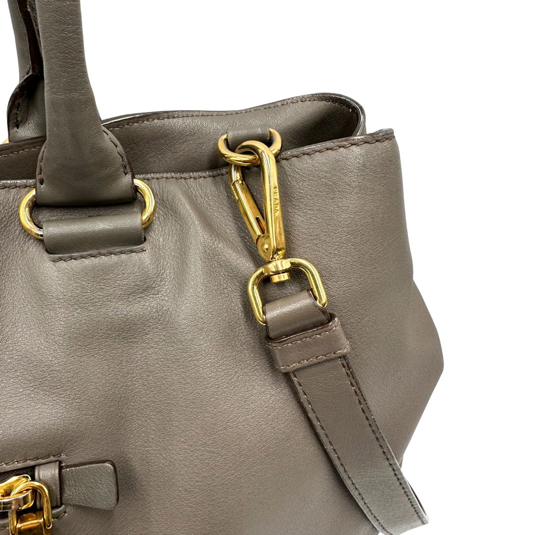 Borsa Prada in pelle color tortora con tracolla e parti metalliche dorate, di lusso, originale, ottime condizioni, usata. 