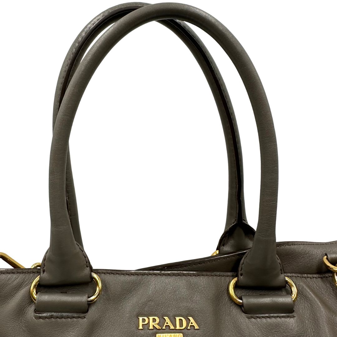 manici Borsa Prada in pelle color tortora con tracolla e parti metalliche dorate, di lusso, originale, ottime condizioni, usata. 