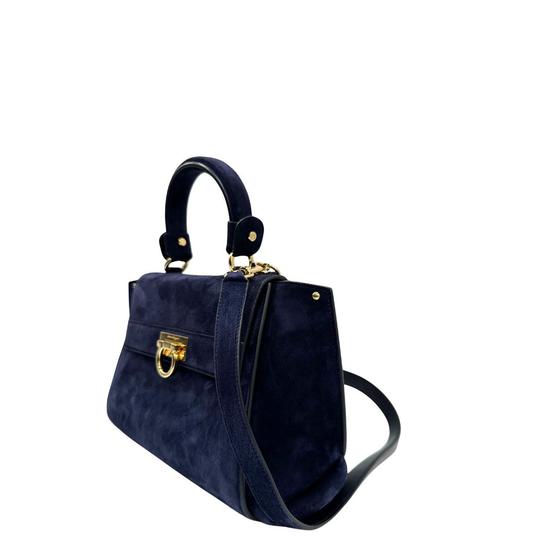 Lato sinistro, Borsa Salvatore Ferragamo realizzata in& pelle scamosciata di colore blu navy, con manico superiore e dettagli in metallo dorato.