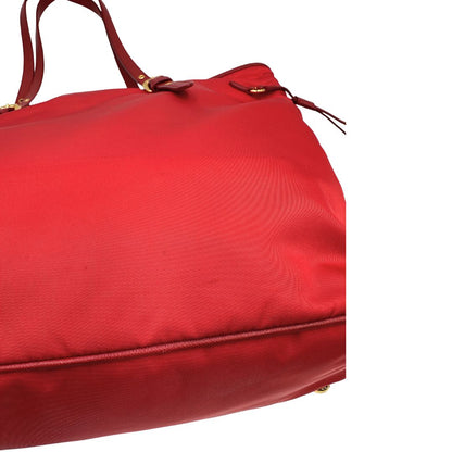 Segni sul tessuto di una borsa Prada in nylon rosso e finiture in pelle saffiano tono su tono, usata, originale, second hand, in ottime condizioni.