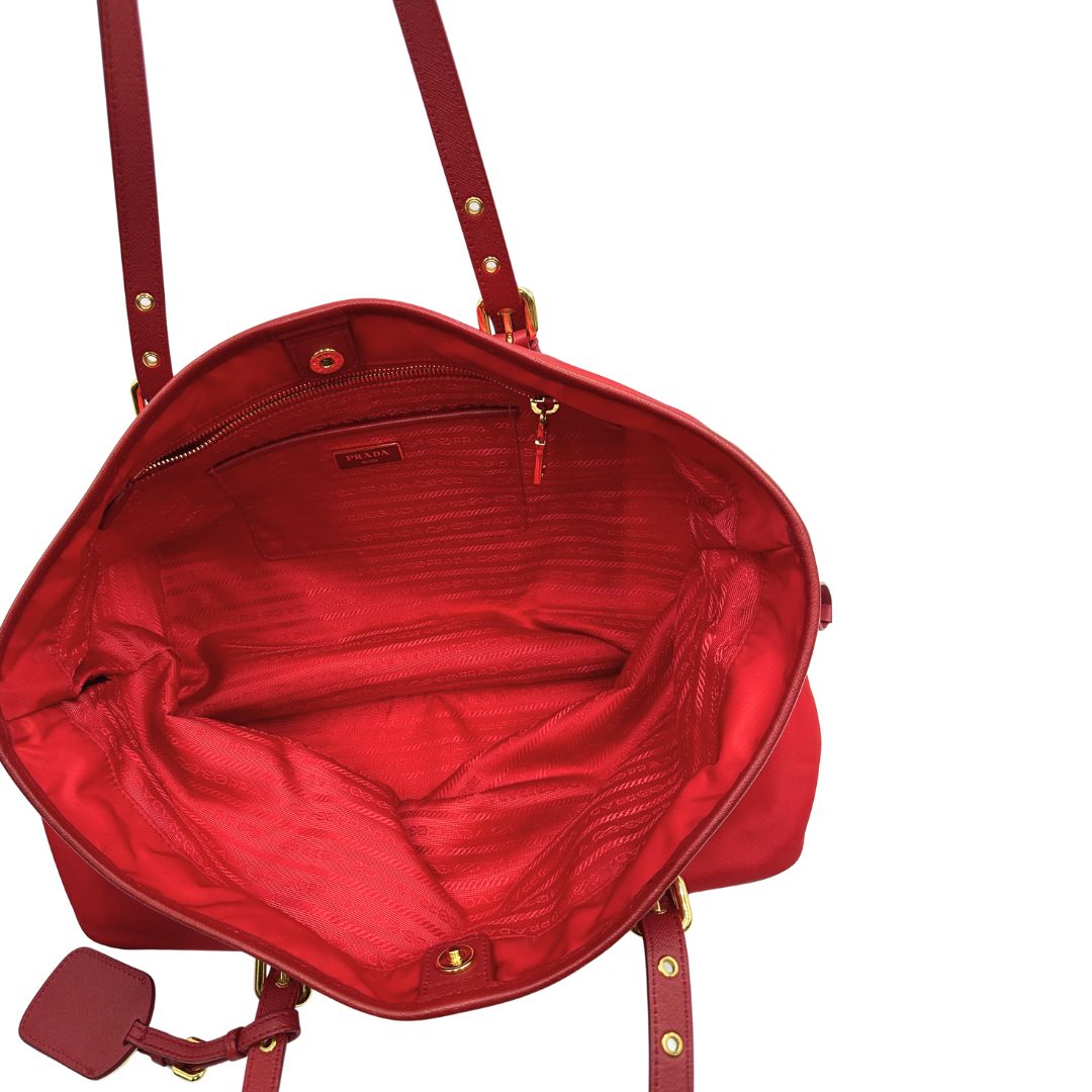 Interno di una borsa Prada in nylon rosso e finiture in pelle saffiano tono su tono, usata, originale, second hand, in ottime condizioni.