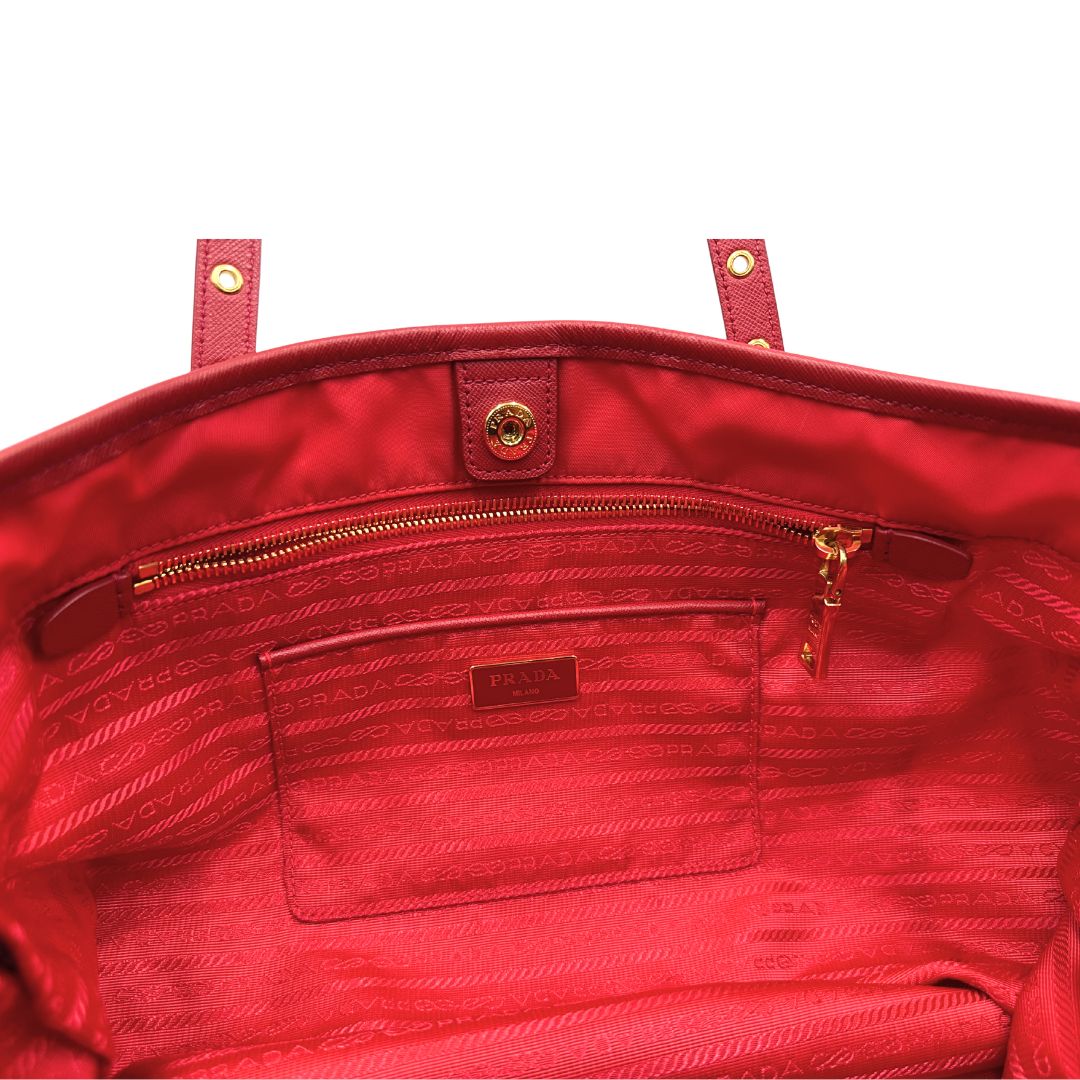 Interno di una borsa Prada in nylon rosso e finiture in pelle saffiano tono su tono, usata, originale, second hand, in ottime condizioni.
