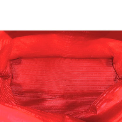 Interno di una borsa Prada in nylon rosso e finiture in pelle saffiano tono su tono, usata, originale, second hand, in ottime condizioni.