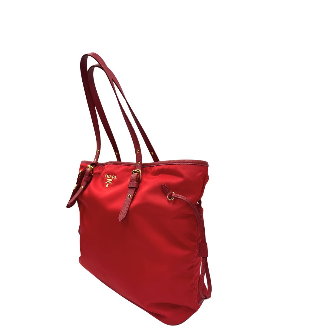 Laterale destro di una borsa Prada in nylon rosso e finiture in pelle saffiano tono su tono, usata, originale, second hand, in ottime condizioni.