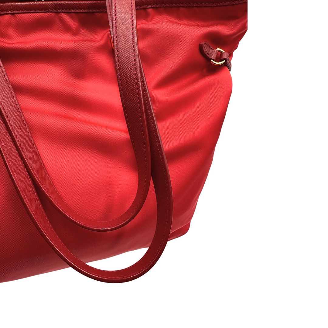Manici di una borsa Prada in nylon rosso e finiture in pelle saffiano tono su tono, usata, originale, second hand, in ottime condizioni.
