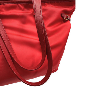 Manici di una borsa Prada in nylon rosso e finiture in pelle saffiano tono su tono, usata, originale, second hand, in ottime condizioni.