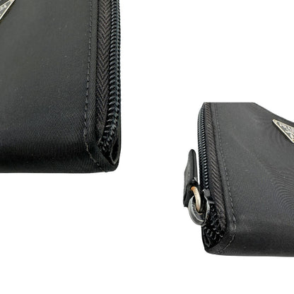 Angoli, Portafoglio Prada in nylon nero con chiusura a zip e l'iconico logo triangolare in metallo. Originale, usato, di lusso, in ottime condizioni.