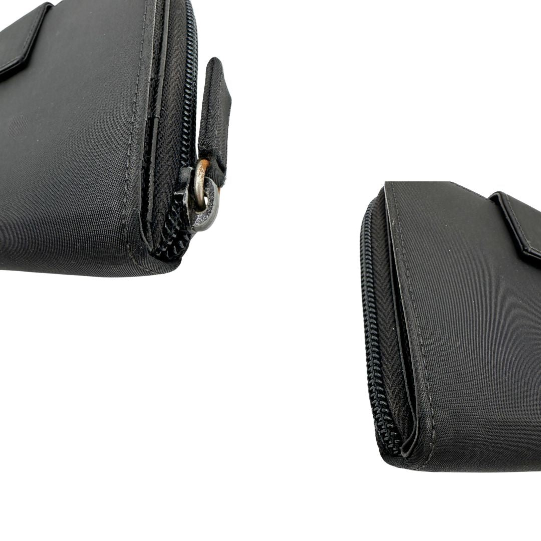 Angoli, Portafoglio Prada in nylon nero con chiusura a zip e l'iconico logo triangolare in metallo. Originale, usato, di lusso, in ottime condizioni.