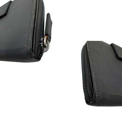 Angoli, Portafoglio Prada in nylon nero con chiusura a zip e l'iconico logo triangolare in metallo. Originale, usato, di lusso, in ottime condizioni.