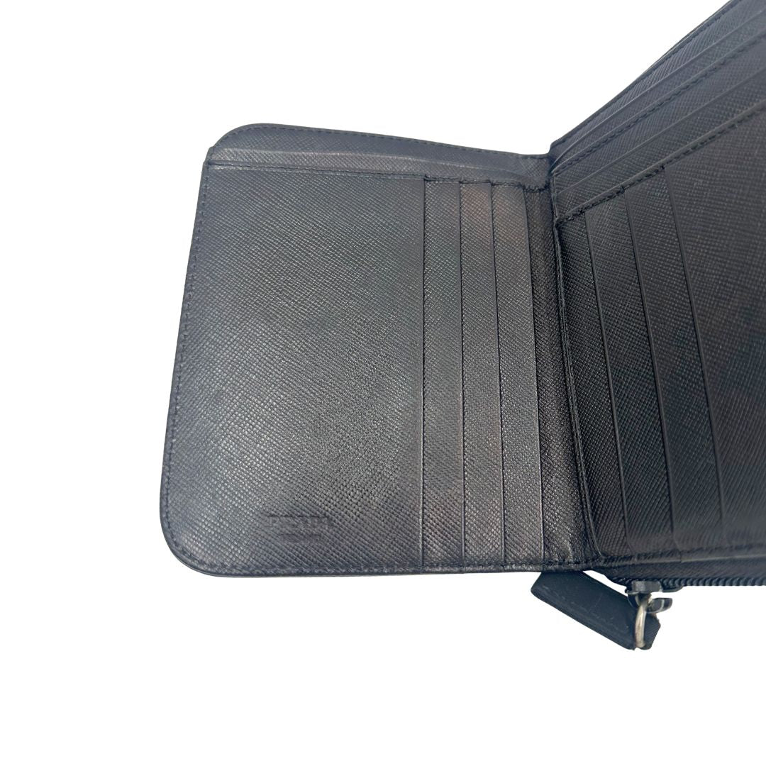 Interno, Portafoglio Prada in nylon nero con chiusura a zip e l'iconico logo triangolare in metallo. Originale, usato, di lusso, in ottime condizioni.