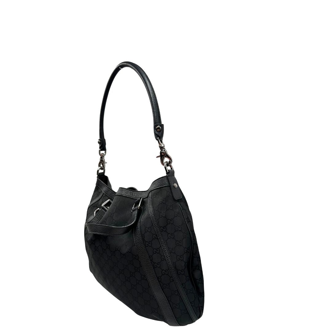 Lato sinistro, Borsa Gucci in tessuto nero trama GG, con parti metalliche argentate, indossabile a mano o a spalla. Originale, usata, di lusso, in ottime condizioni.