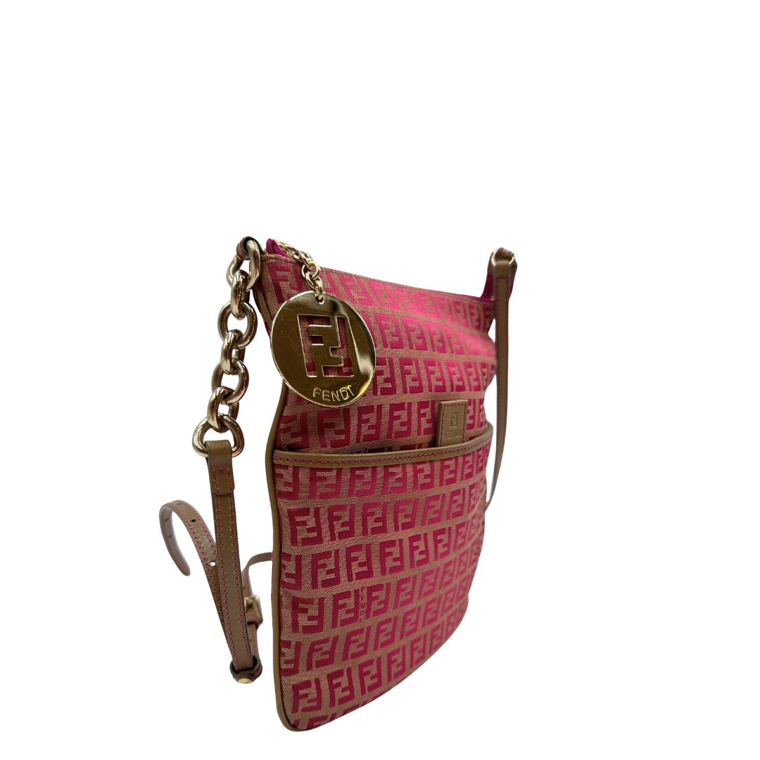 Laterale sinistro di una tracolla Fendi fucsia in trama Zucchino con finiture in pelle color biscotto e piccolo charm logato come tirante, usata, originale, second hand, in ottime condizioni.