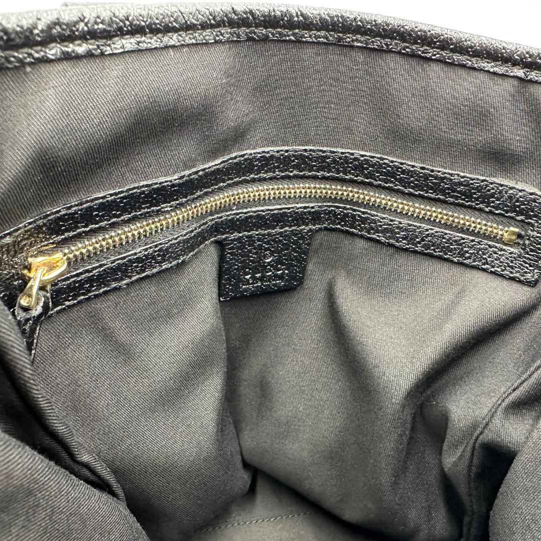 Interno di una borsa a spalla Gucci in tessuto nero trama GG, con parti metalliche dorate, usata, originale, second hand, in ottime condizioni.
