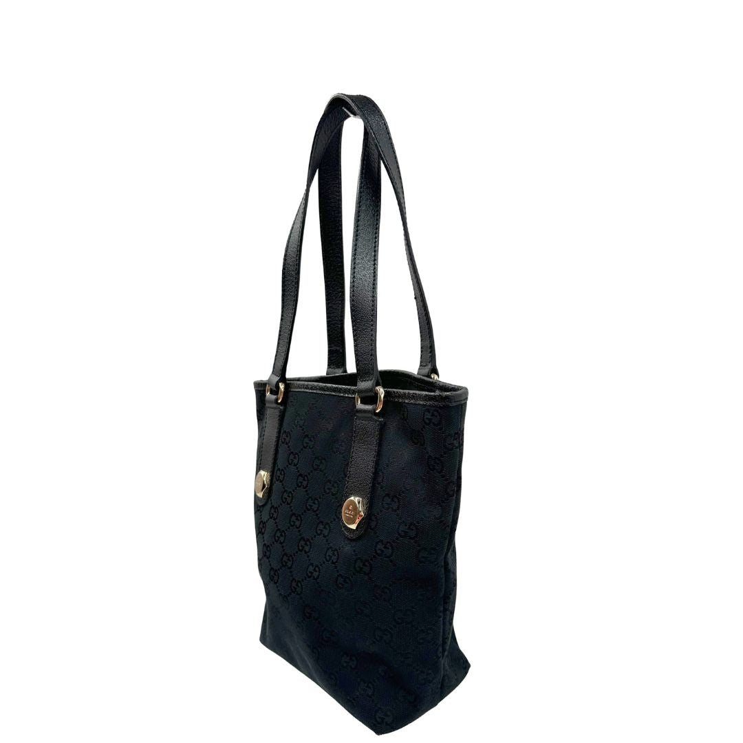 Laterale destro di una borsa a spalla Gucci in tessuto nero trama GG, con parti metalliche dorate, usata, originale, second hand, in ottime condizioni.
