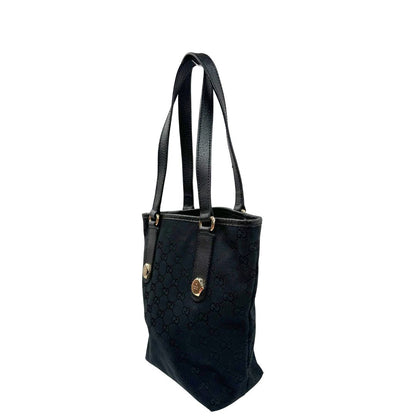 Laterale destro di una borsa a spalla Gucci in tessuto nero trama GG, con parti metalliche dorate, usata, originale, second hand, in ottime condizioni.