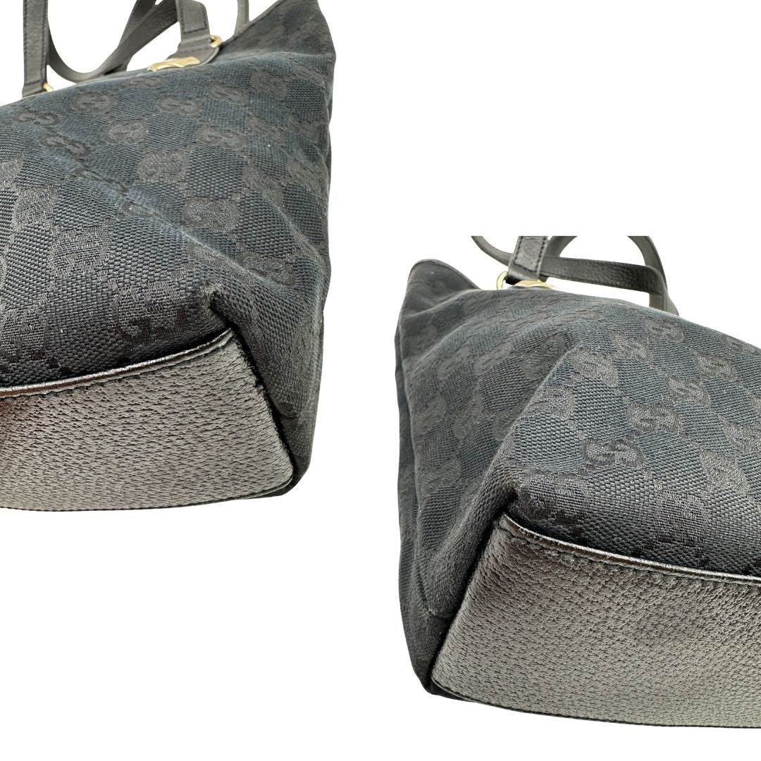 Angoli di una borsa a spalla Gucci in tessuto nero trama GG, con parti metalliche dorate, usata, originale, second hand, in ottime condizioni.
