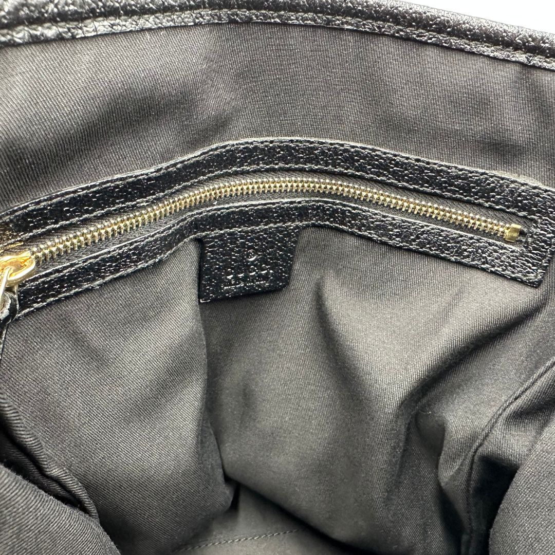 Interno di una borsa a spalla Gucci in tessuto nero trama GG, con parti metalliche dorate, usata, originale, second hand, in ottime condizioni.