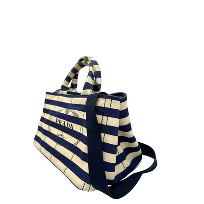 Lato sinistro, Borsa Prada in tela caratterizzato da una fantasia a righe orizzontali blu navy e avorio, Indossabile a mano oppure a tracolla.