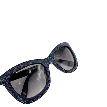Occhiali da sole Jimmy Choo nella variante colore FIALF Blue Grey con una montatura in acetato blu impreziosita da un effetto glitterato e lenti grigio sfumato. Originale, usati, di lusso, in ottime condizioni.
