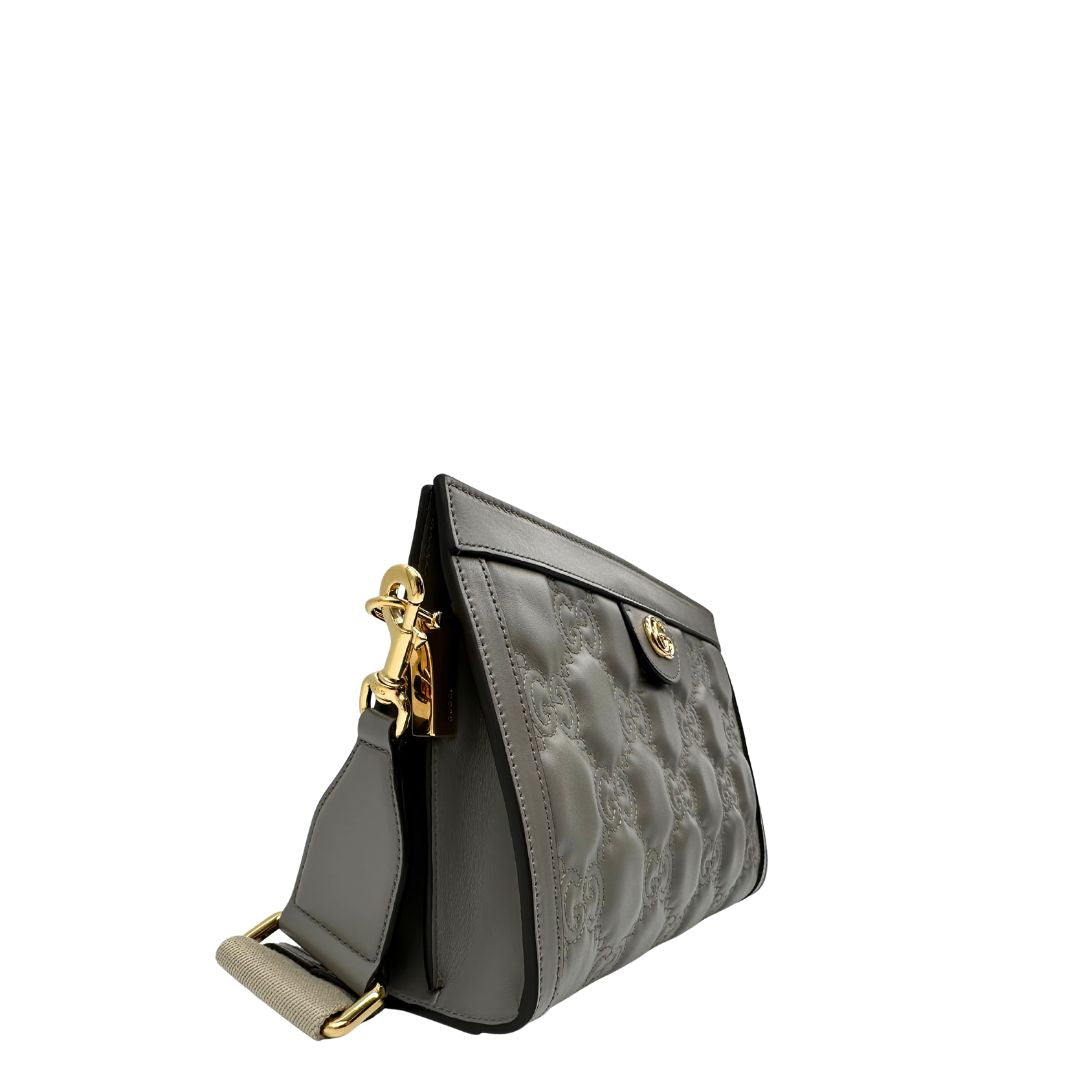 Lato destro, Borsa Gucci in pelle matelassè grigia GG con parti metalliche dorate. Indossabile a tracolla oppure a mano. Originale, usata, di lusso, in condizioni eccellenti.