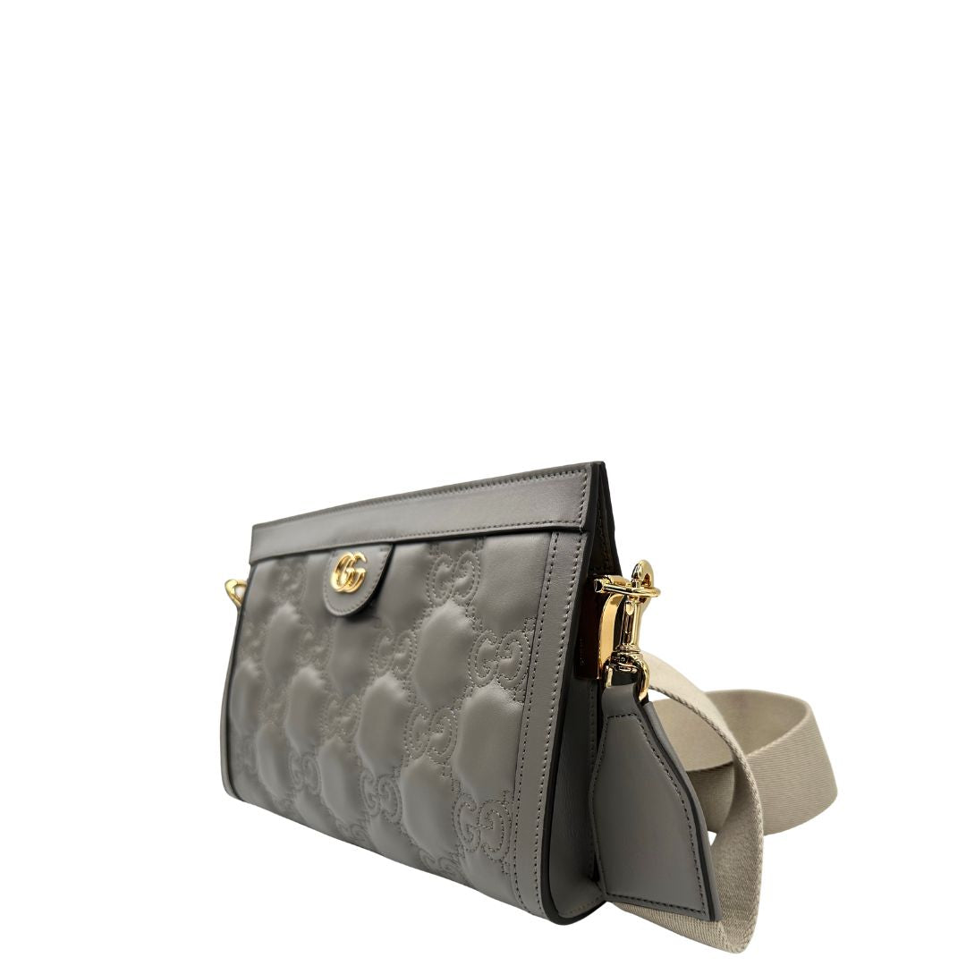 Lato sinistro, Borsa Gucci in pelle matelassè grigia GG con parti metalliche dorate. Indossabile a tracolla oppure a mano. Originale, usata, di lusso, in condizioni eccellenti.