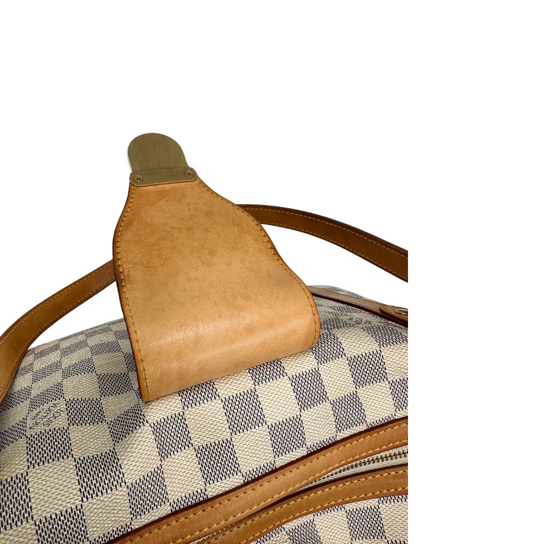 Patta di chiusura di una borsa Louis Vuitton Stresa realizzata in tela Damier Azur con hardware dorato, usata, originale, second hand, in ottime condizioni.