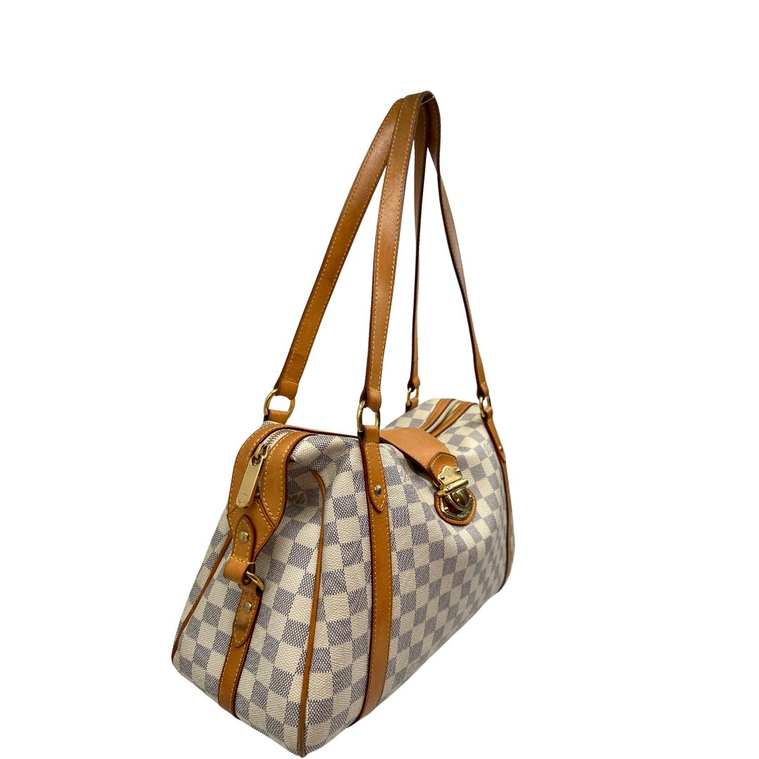 Laterale sinistro di una borsa Louis Vuitton Stresa realizzata in tela Damier Azur con hardware dorato, usata, originale, second hand, in ottime condizioni.