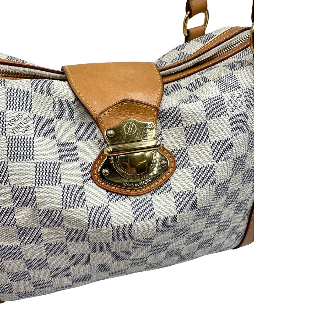 Gancio di chiusura di una borsa Louis Vuitton Stresa realizzata in tela Damier Azur con hardware dorato, usata, originale, second hand, in ottime condizioni.