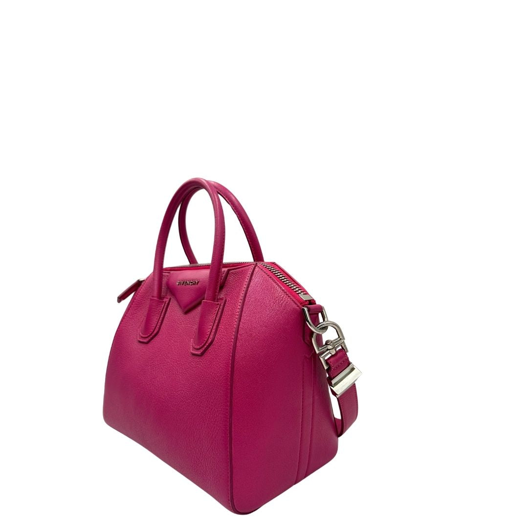Lato sinistro, Compatta borsa Givenchy Antigona in pelle martellata fucsia nella versione piccola con hardware argentato. Indossabile a mano oppure a tracolla. Originale, usata, di lusso, in ottime condizioni.