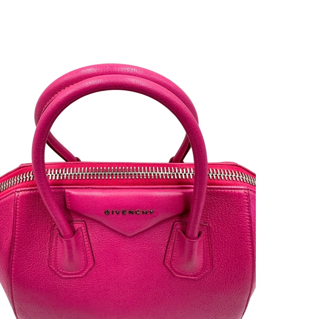 Manici, Compatta borsa Givenchy Antigona in pelle martellata fucsia nella versione piccola con hardware argentato. Indossabile a mano oppure a tracolla. Originale, usata, di lusso, in ottime condizioni.