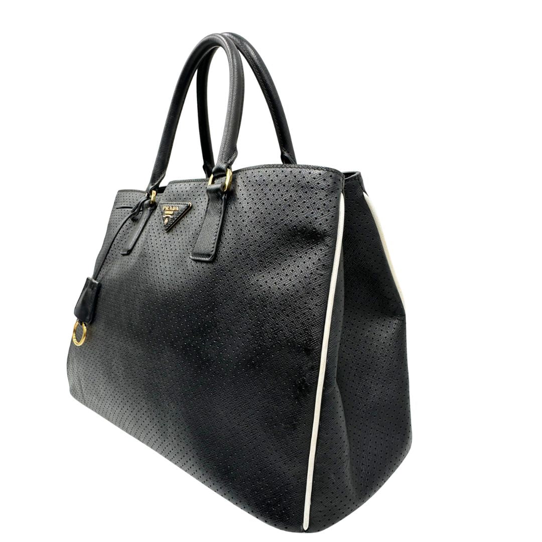 lato Borsa Prada Galleria in pelle traforata nera con eleganti profili bianchi, di lusso, originale, ottime condizioni, usata. 