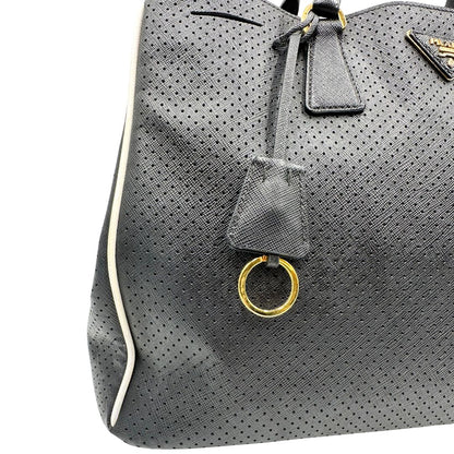 lato Borsa Prada Galleria in pelle traforata nera con eleganti profili bianchi, di lusso, originale, ottime condizioni, usata. 
