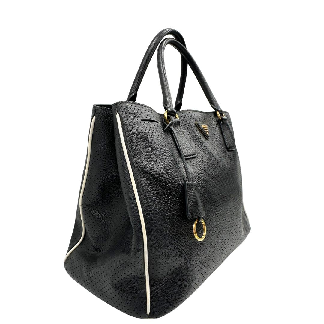 lato Borsa Prada Galleria in pelle traforata nera con eleganti profili bianchi, di lusso, originale, ottime condizioni, usata. 