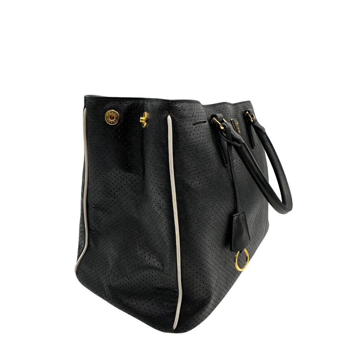 lato Borsa Prada Galleria in pelle traforata nera con eleganti profili bianchi, di lusso, originale, ottime condizioni, usata. 