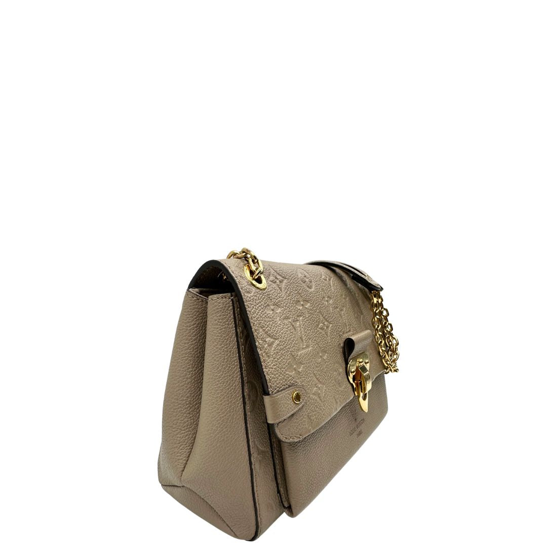 Lato destro, Borsa Vavin LV in pelle color fango monogram Empreinte, munita di una tracolla scorrevole con spallacci in pelle.