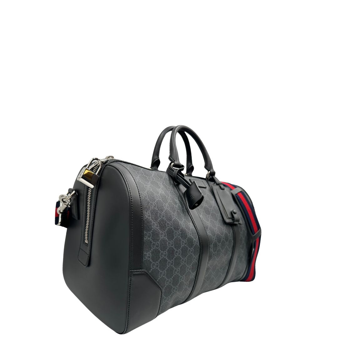 Lato destro, Borsone da viaggio Gucci Savoy misura piccola in canvas GG supreme nero con parti metalliche argentate, da portare a mano oppure a spalla. Originale, usato, di lusso, in ottime condizioni.