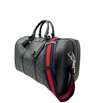 Lato sinistro, Borsone da viaggio Gucci Savoy misura piccola in canvas GG supreme nero con parti metalliche argentate, da portare a mano oppure a spalla. Originale, usato, di lusso, in ottime condizioni.