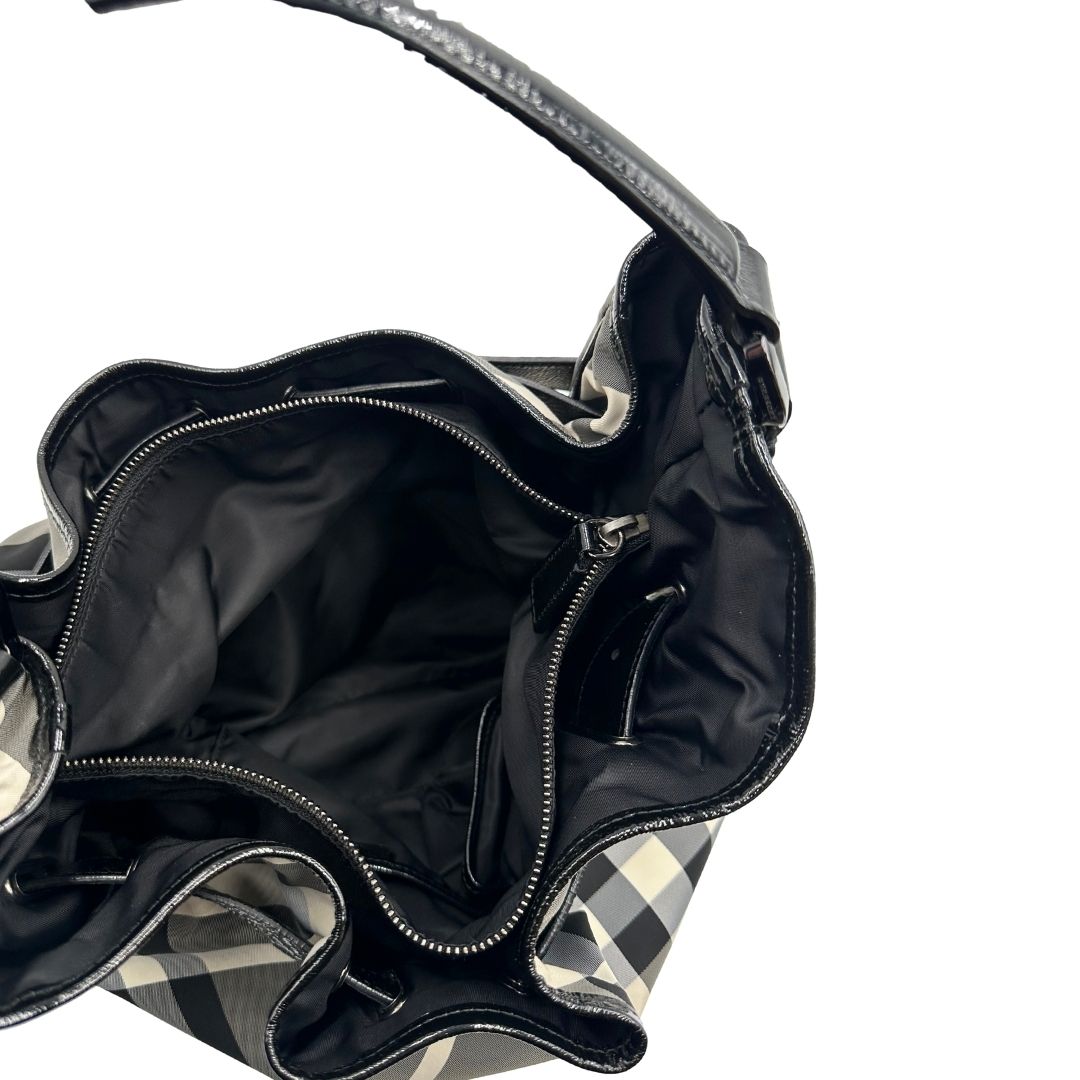 Interno di una borsa Burberry in poliammide e acrilico trama tartan, con finiture nere lucide, usata, originale, second hand, in ottime condizioni.